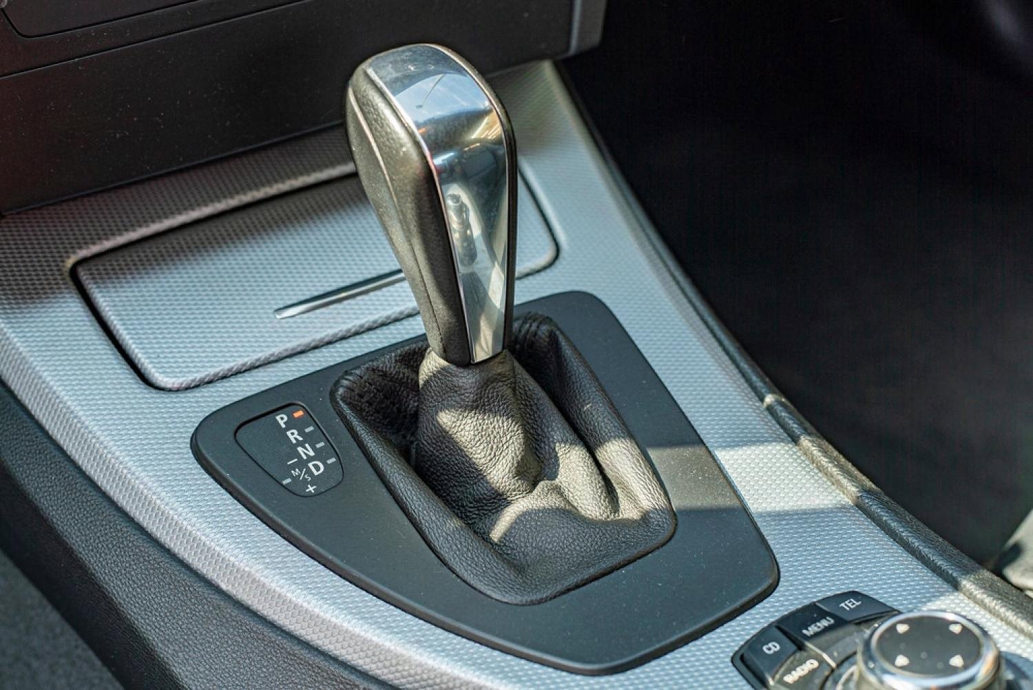 Close-up of a car gear selector and centre console inside a vehicle parked under the UAE sun