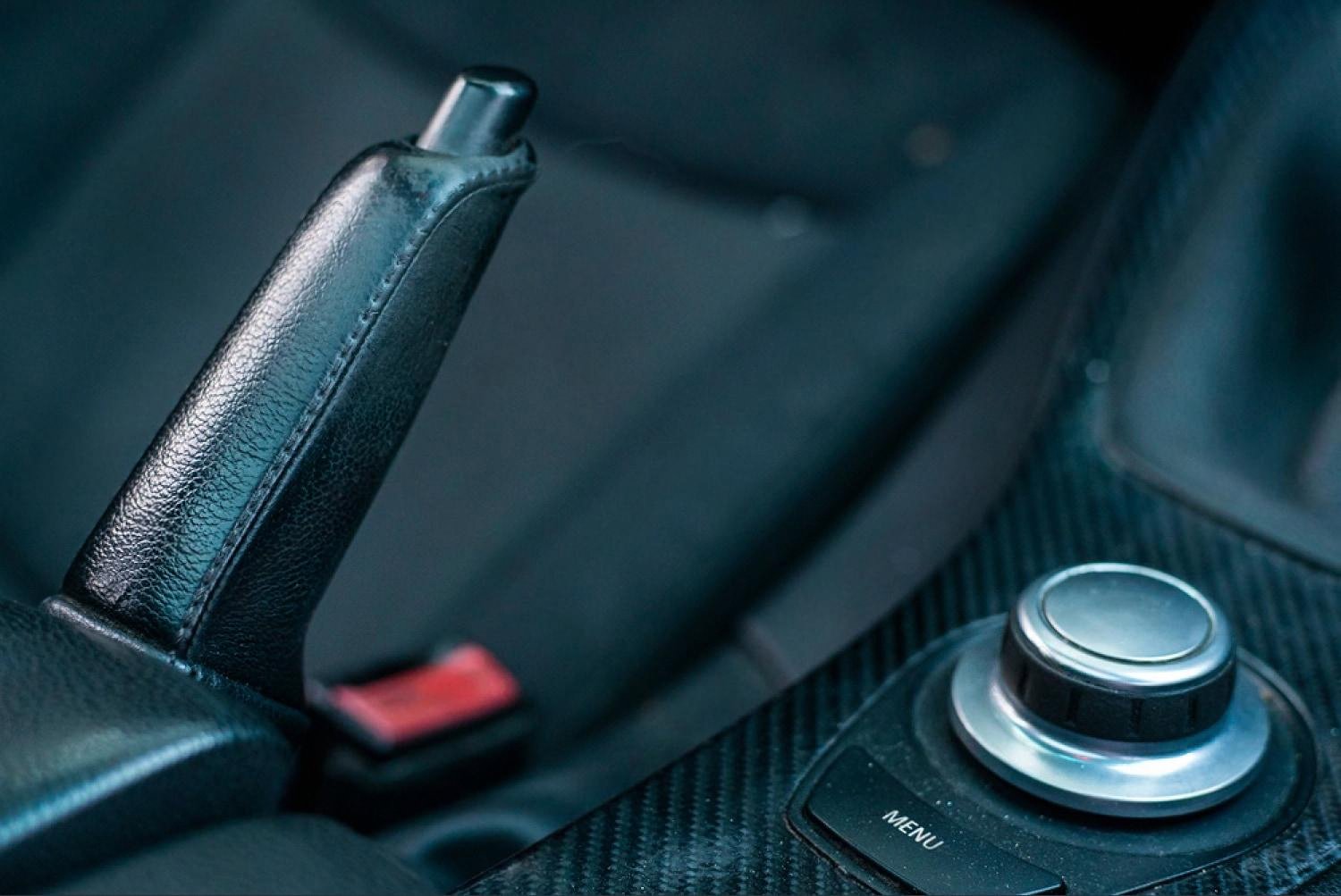 Leather handbrake and dark interior trim showing sun exposure inside a car in the UAE
